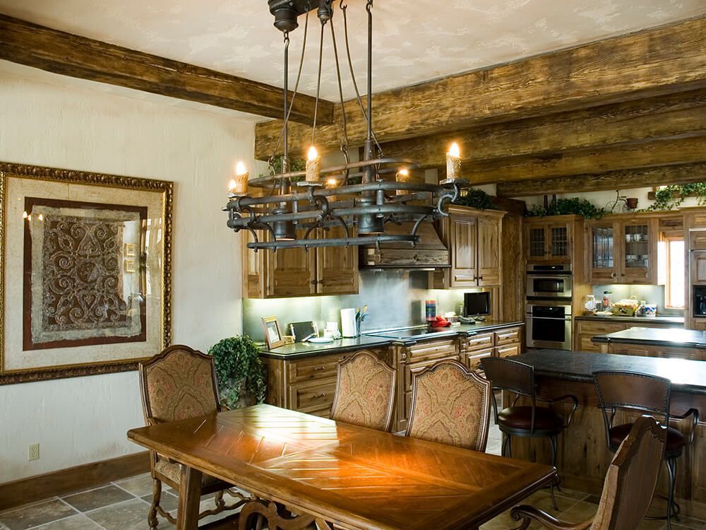 A kitchen with a table and chairs and a chandelier hanging from the ceiling