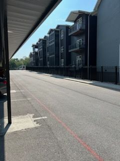 A row of apartment buildings are lined up on the side of a street.