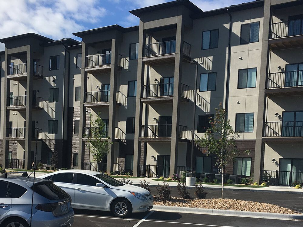 A large apartment building with cars parked in front of it