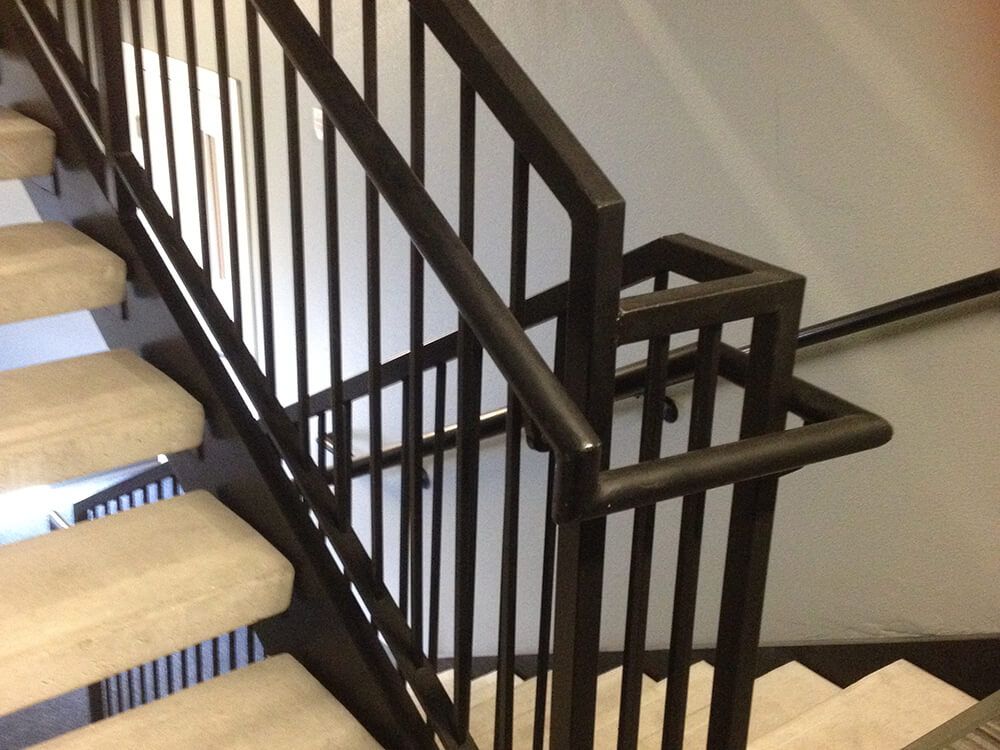 A close up of a staircase with a black railing