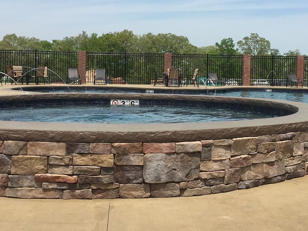 A large swimming pool with a stone wall around it
