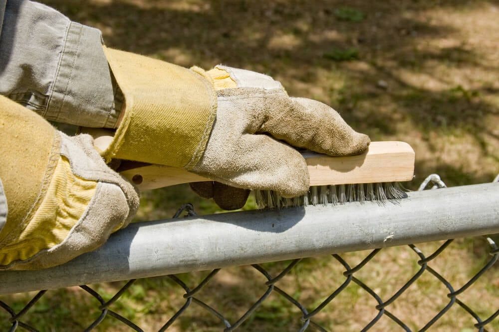 man scrubbing chain fence in springfield mo
