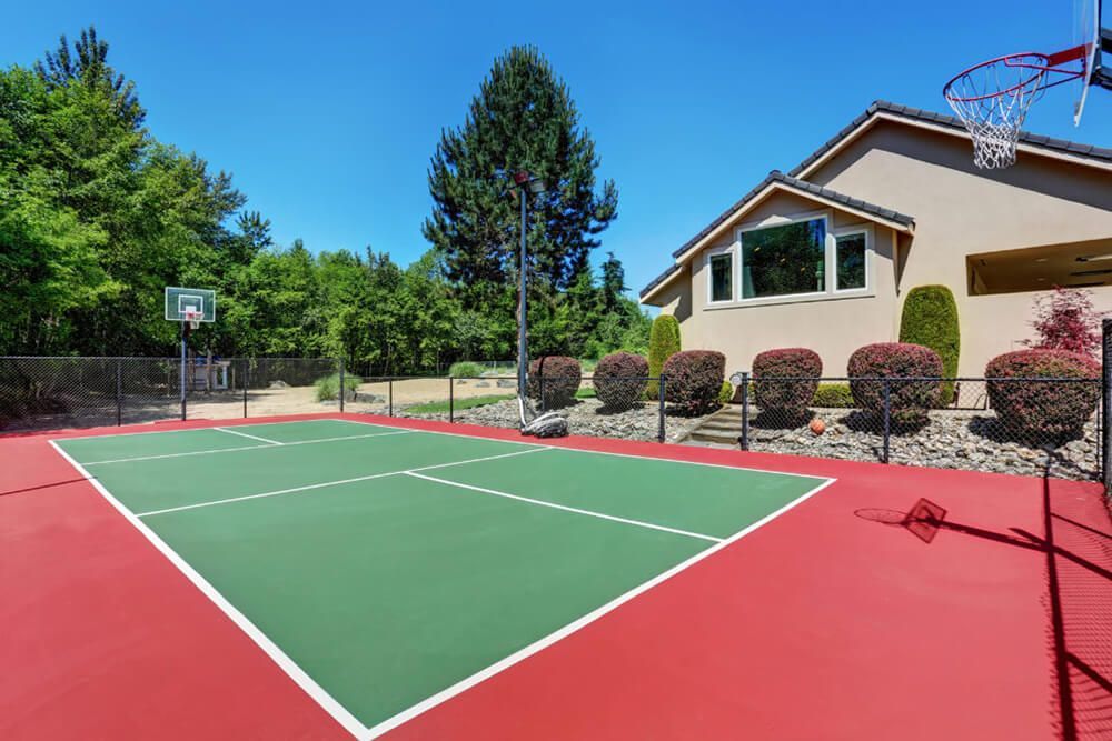 There is a basketball court in front of a house.