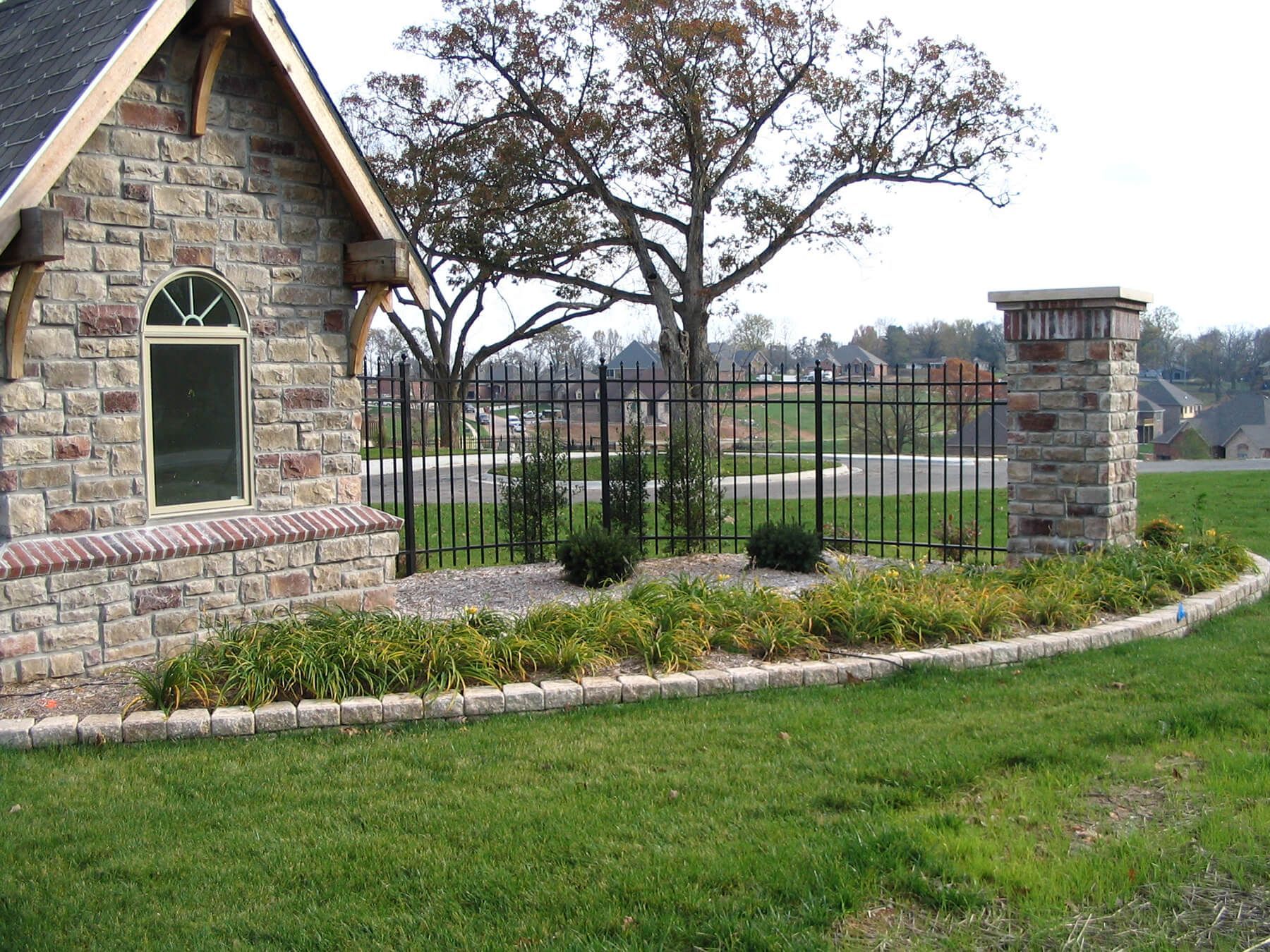 A stone building with a window and a fence in front of it