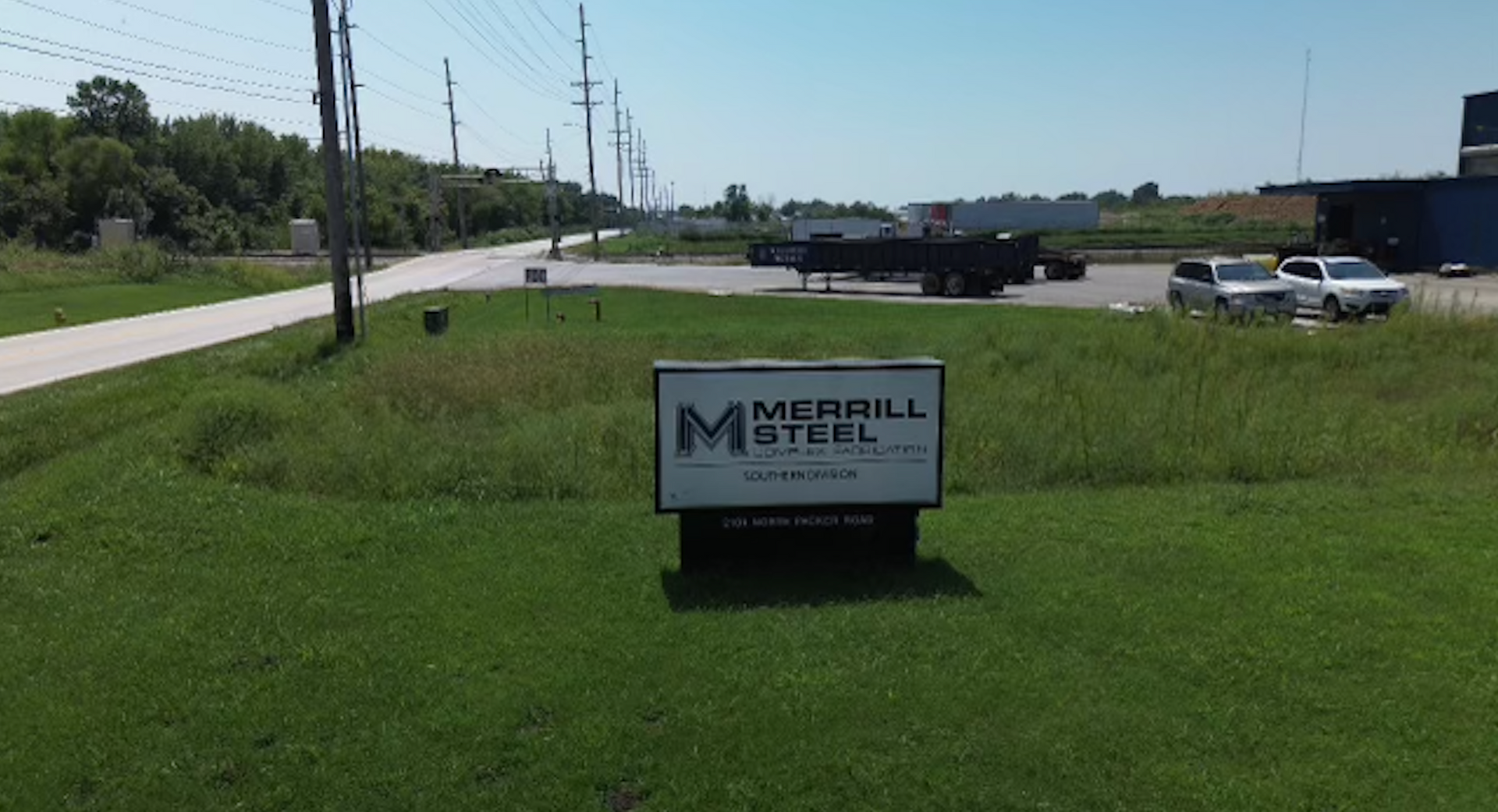 An aerial view of a sign in the middle of a grassy field.