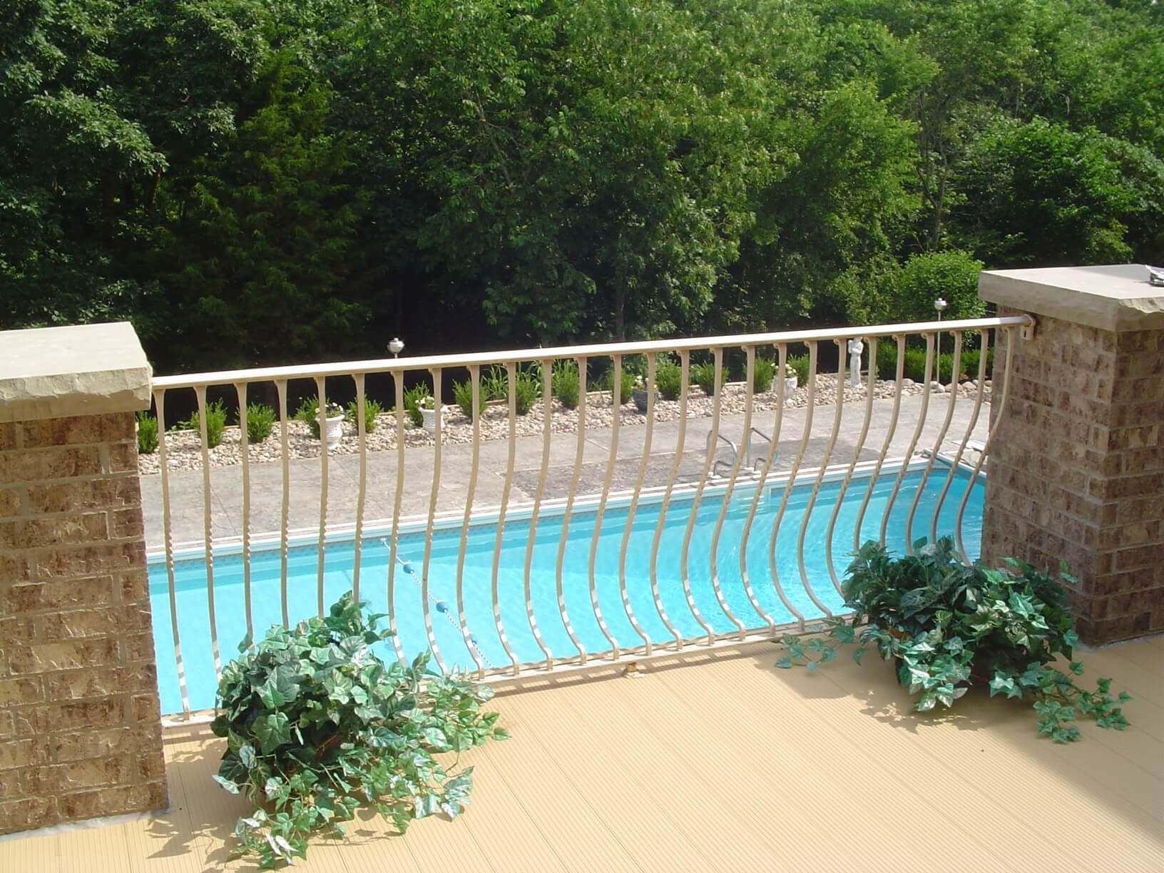 A balcony overlooking a swimming pool with trees in the background