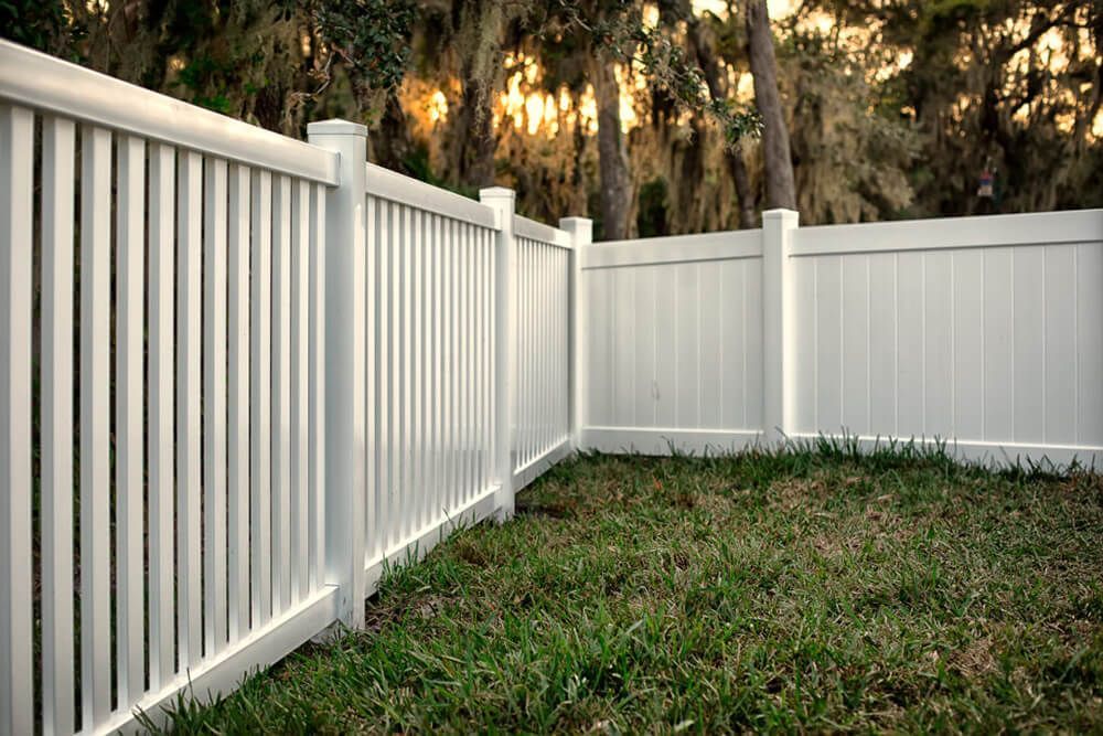 A white vinyl fence surrounds a lush green yard | Fencing done by top fencing company in Springfield MO