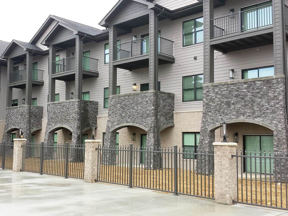 A row of apartment buildings with balconies behind a fence | Commercial ironworks springfield mo