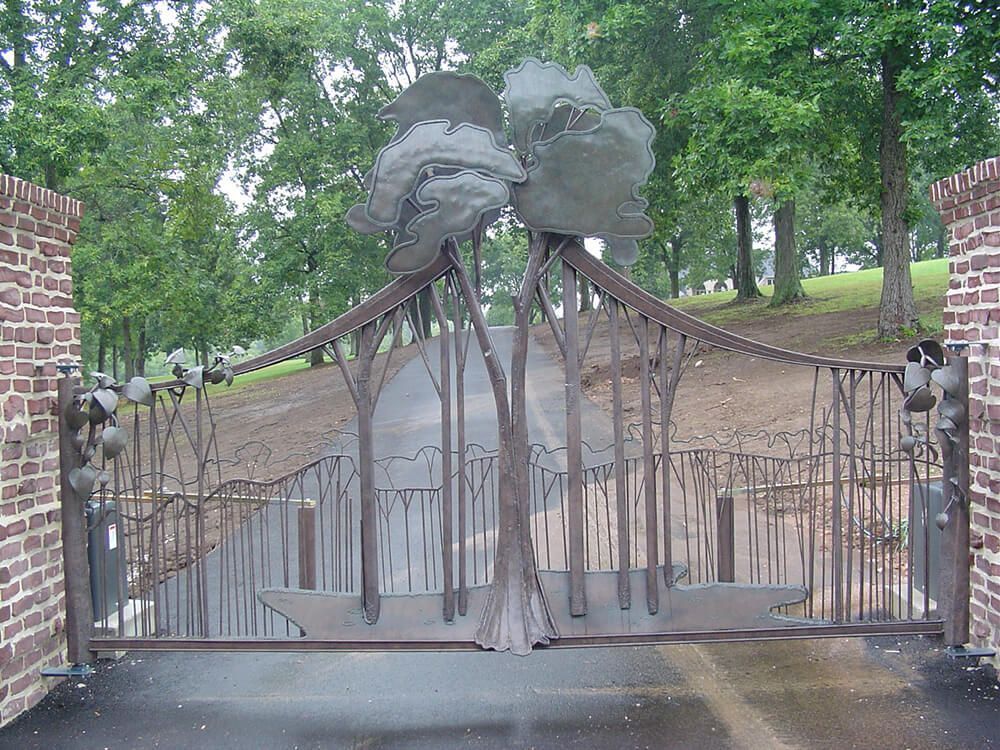 A wrought iron gate with a sculpture of trees on it