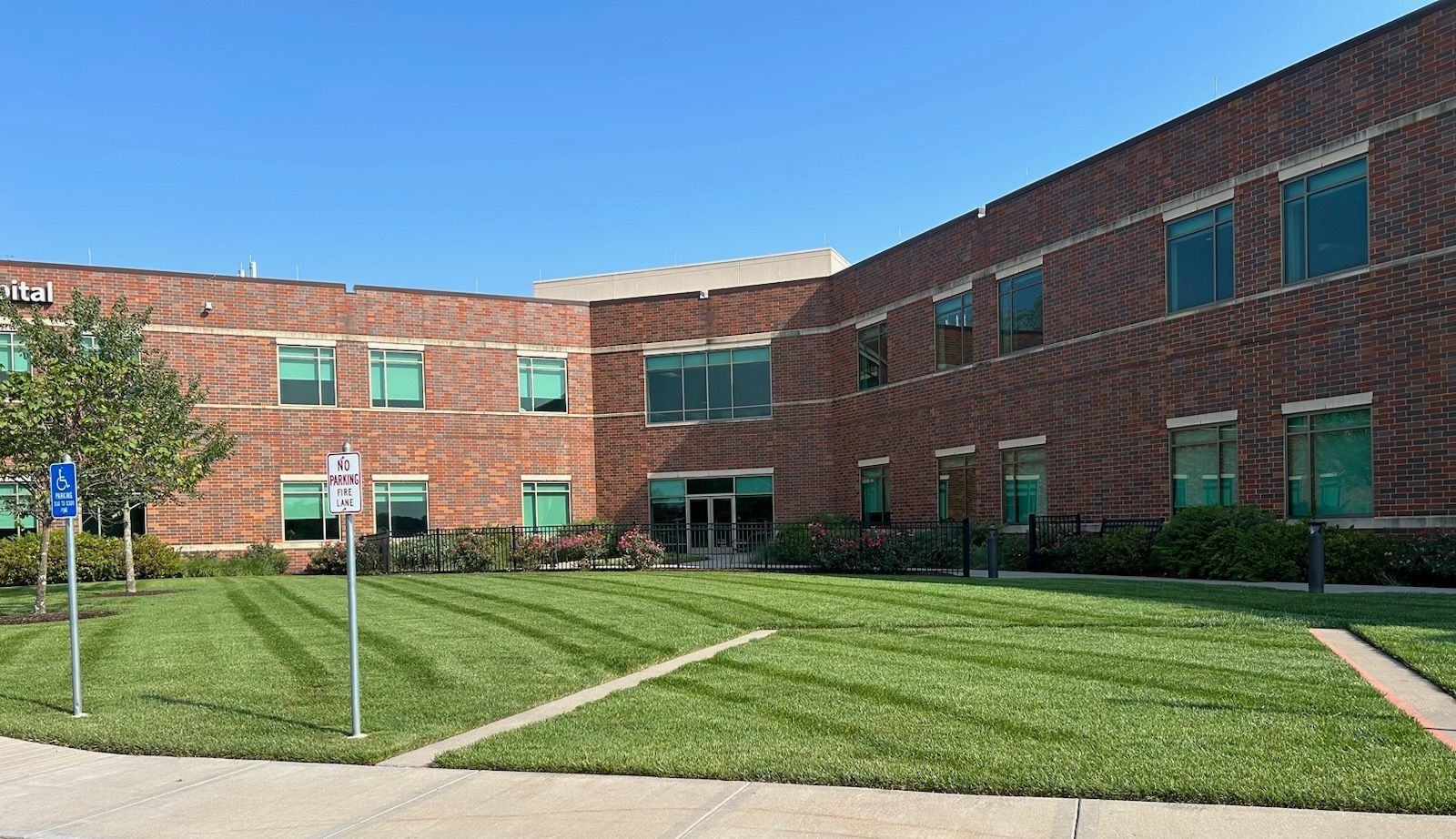 A large brick building with a lush green lawn in front of it