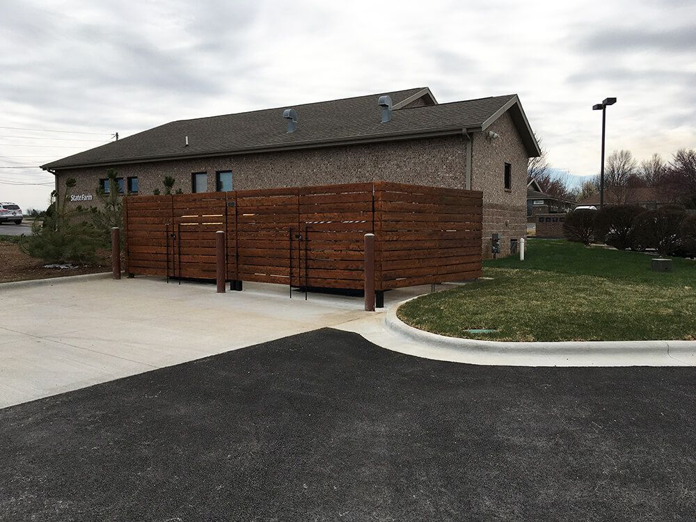A large building with a wooden fence in front of it