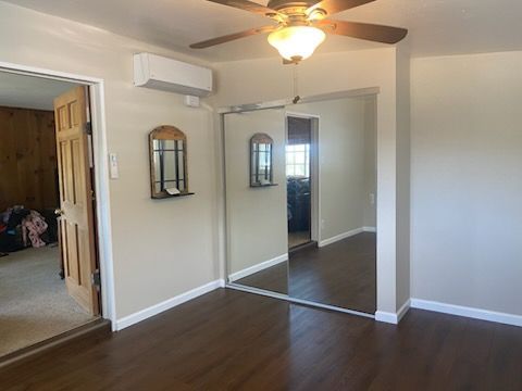 A bedroom with a large mirror and a ceiling fan.