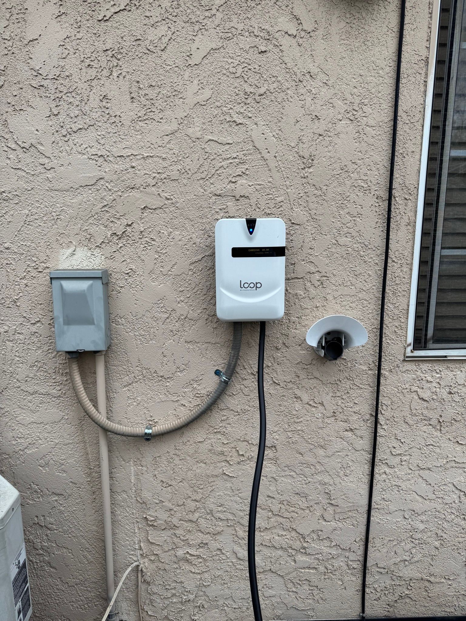 A white box is attached to the side of a building.