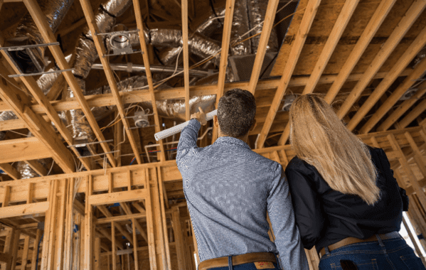 Interior view of an under-construction home showing installed air ducts on wooden frames.