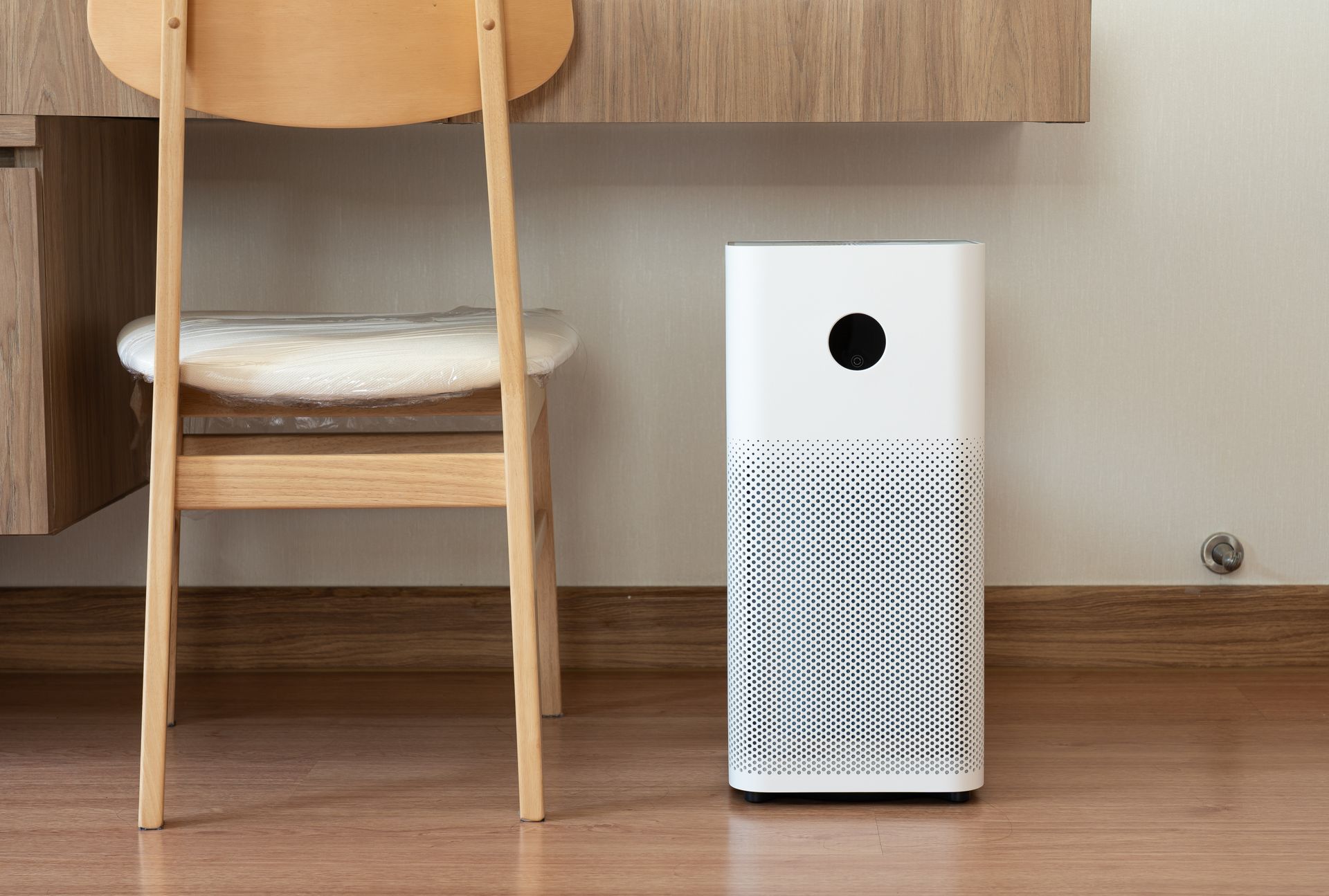 n indoor air purifier with a digital monitor screen in a bedroom, displaying real-time air quality and pollution levels in the room.