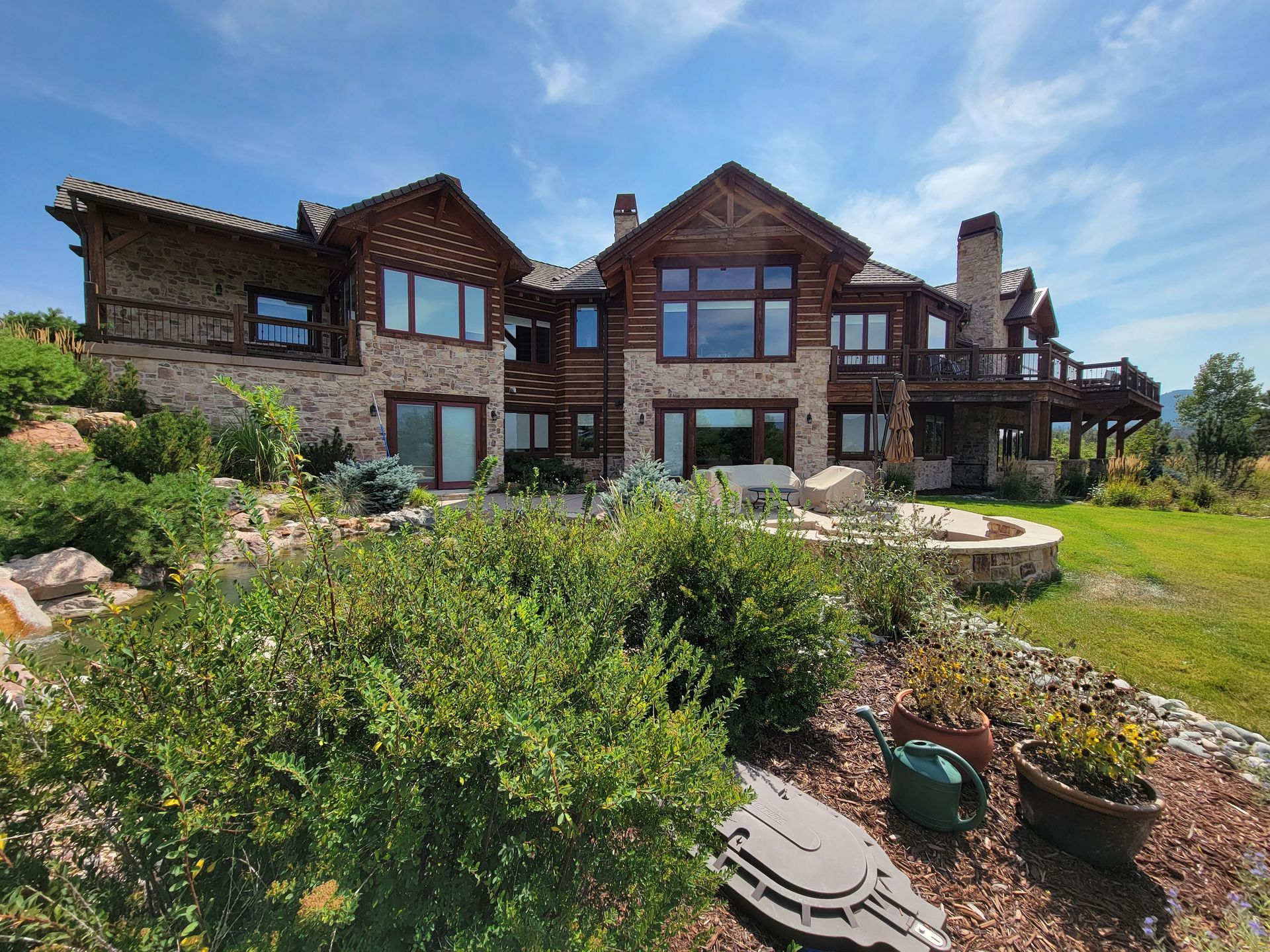 A large house with a lot of windows sits on top of a hill