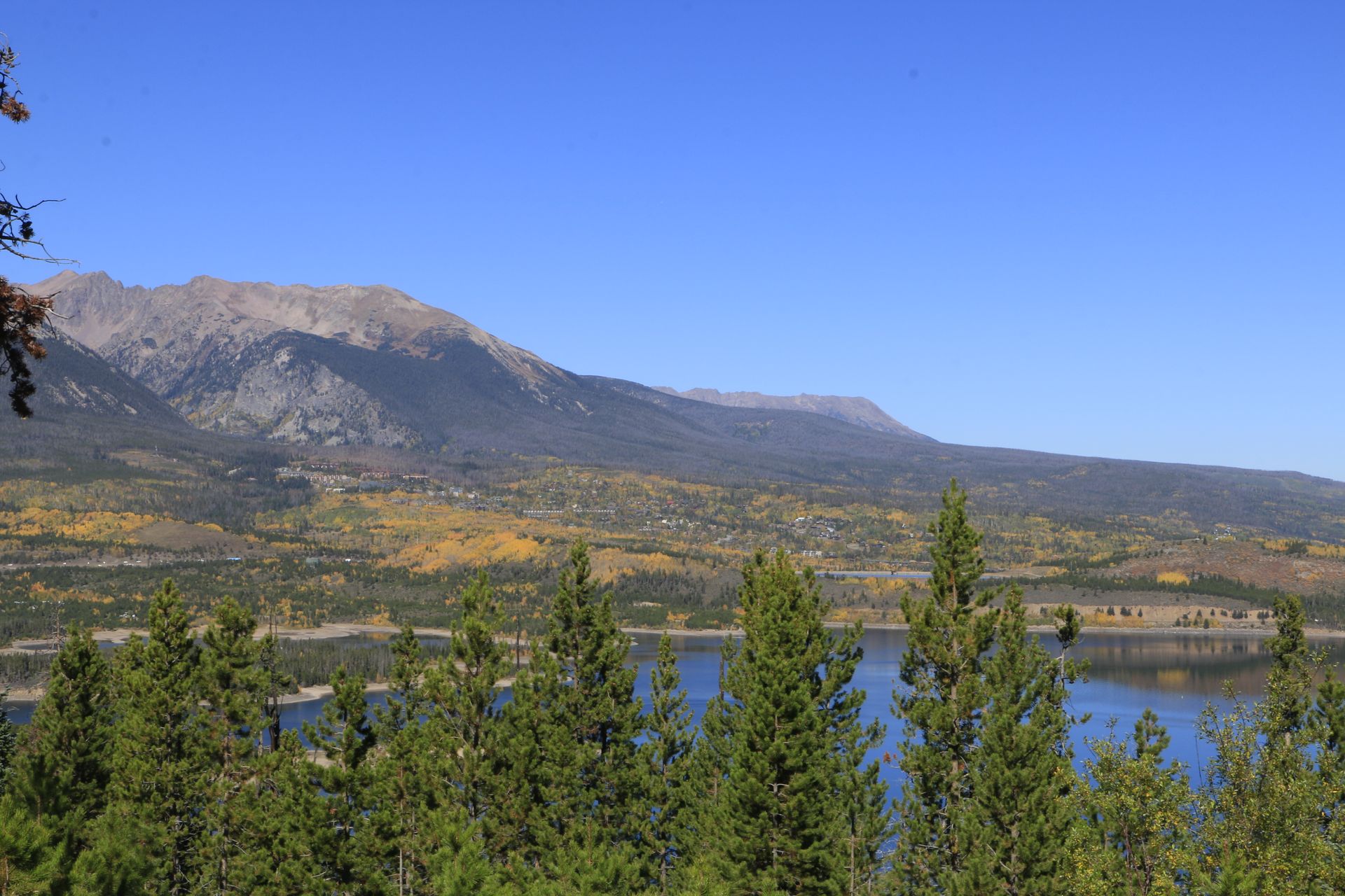 Lake Dillon in Fall surrounded by trees with mountains in the background