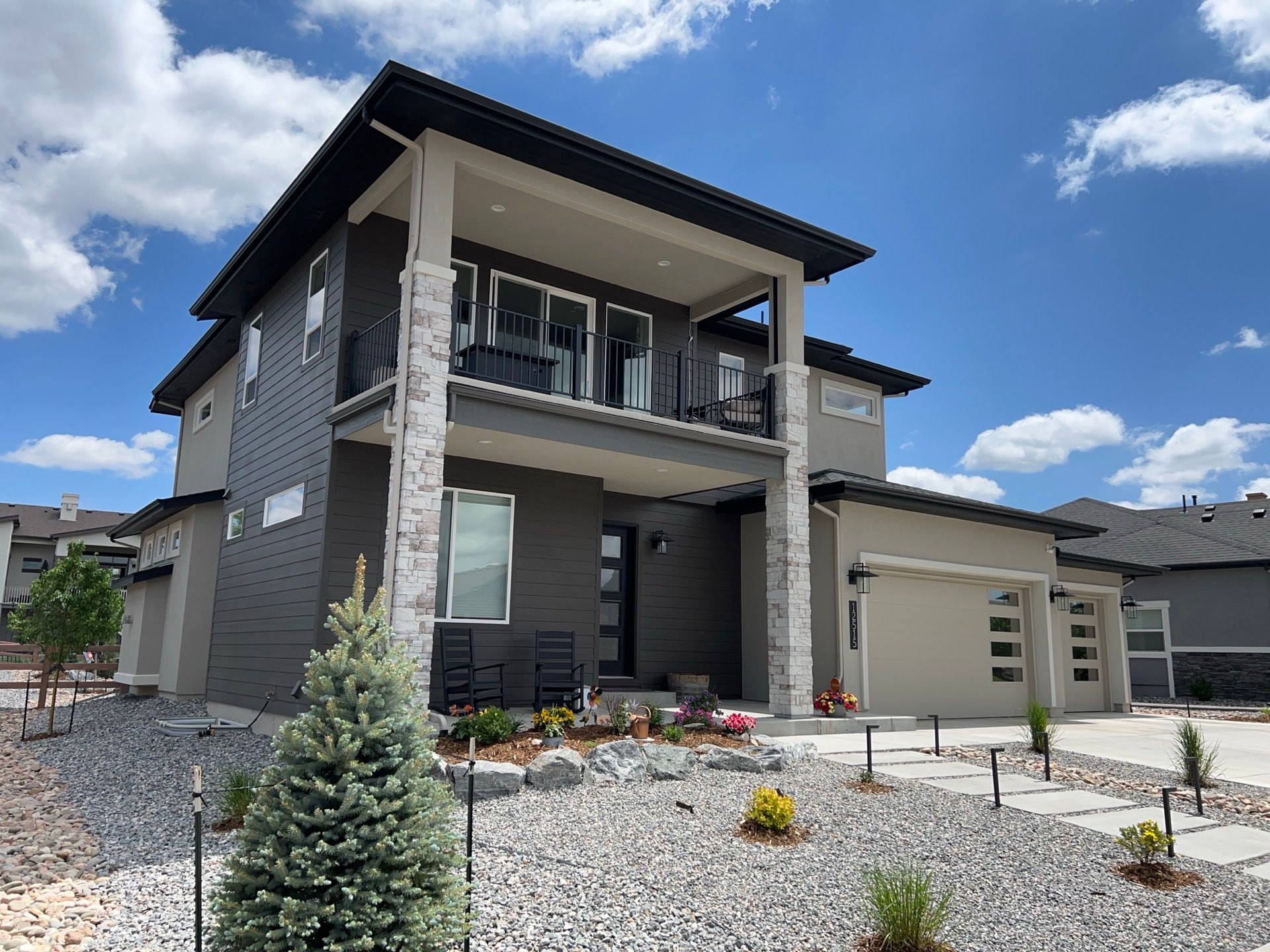 A large house with a lot of windows and a lot of rocks in front of it.