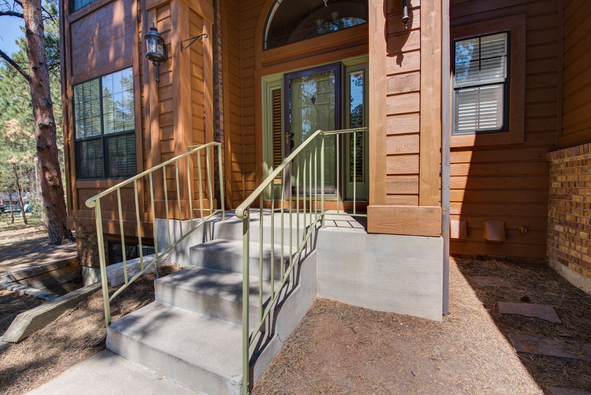 A wooden house with stairs leading up to the front door.