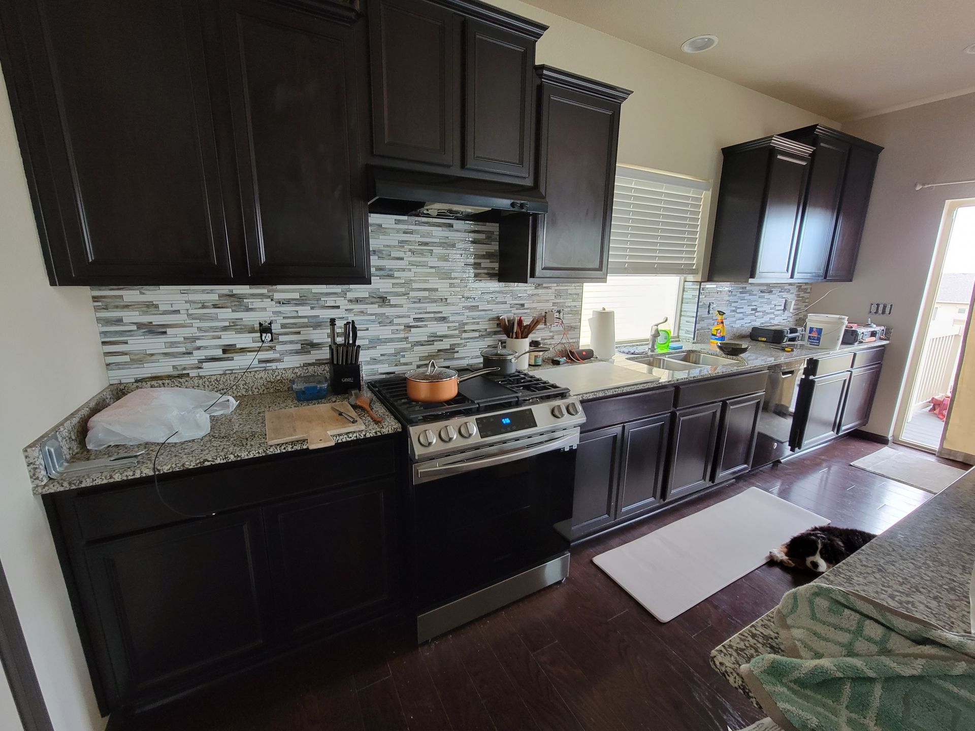 A kitchen with black cabinets and stainless steel appliances