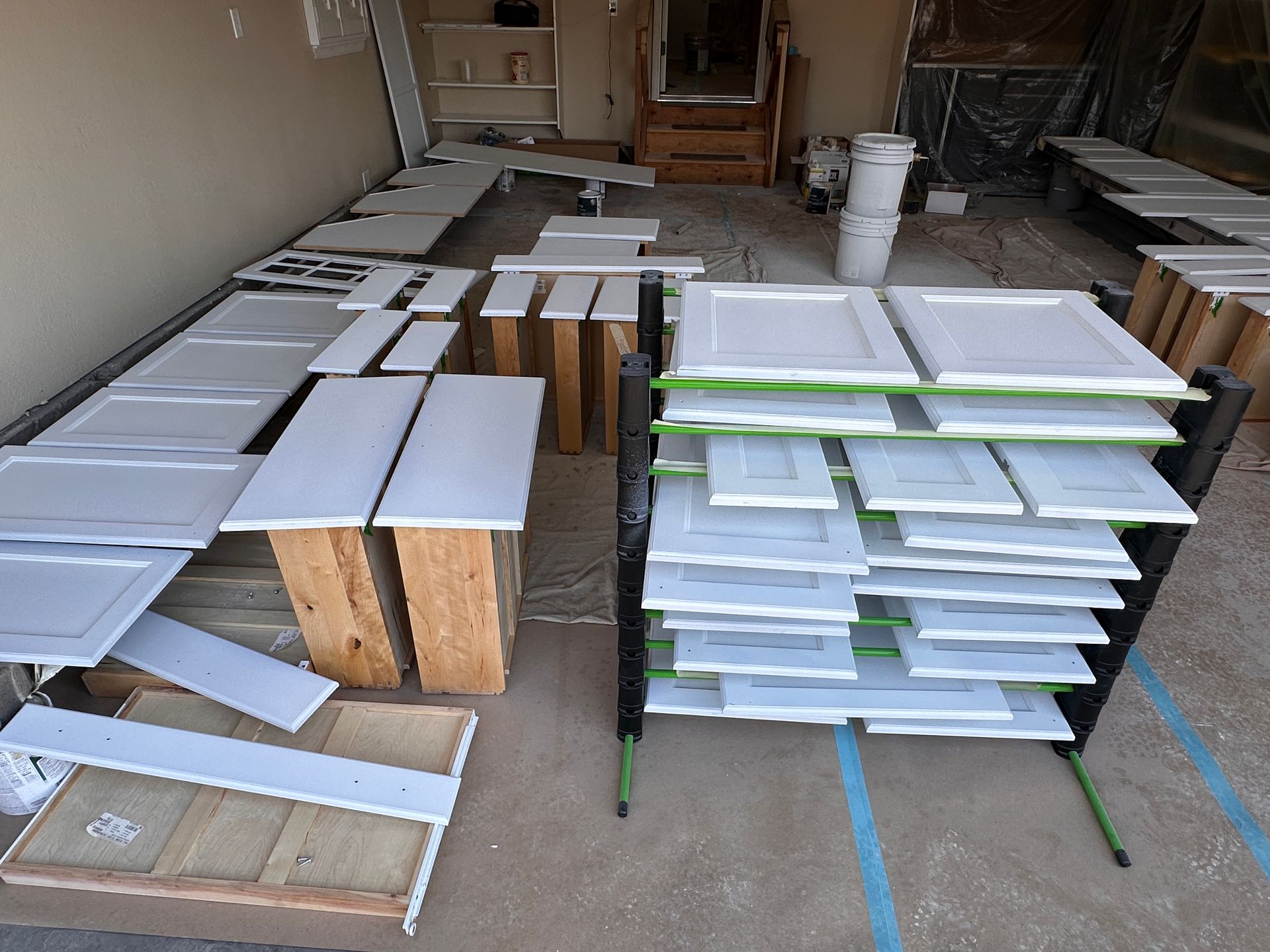 A bunch of cabinets are being painted in a garage