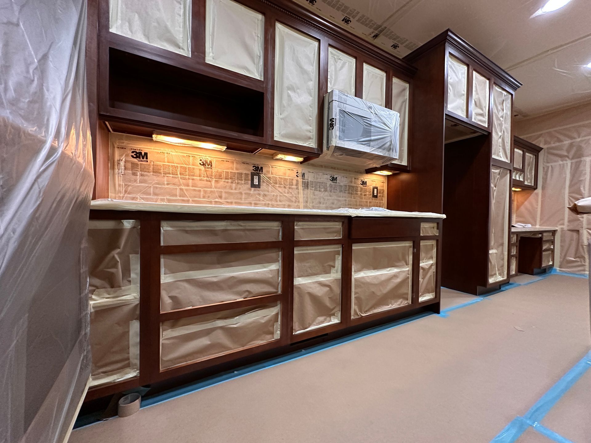 A kitchen is being remodeled and covered in plastic.