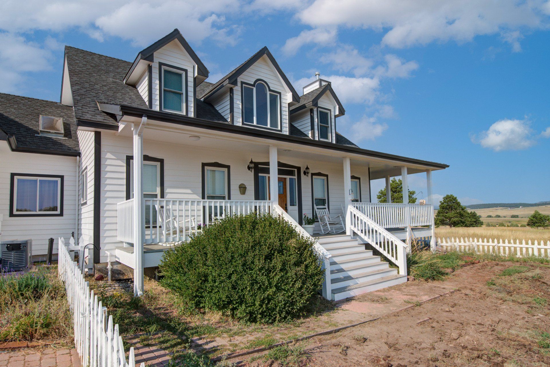 A large white house with a porch and stairs