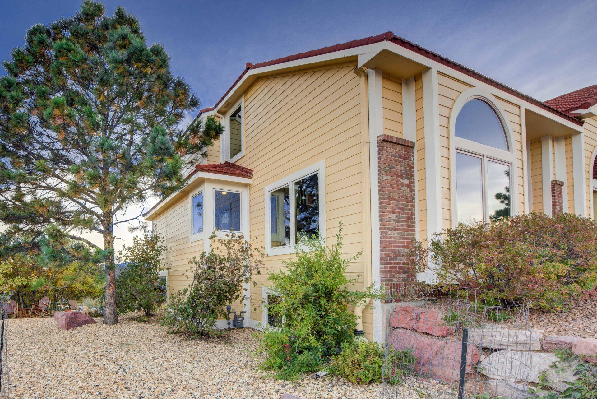 a large yellow house with a red roof and a lot of windows