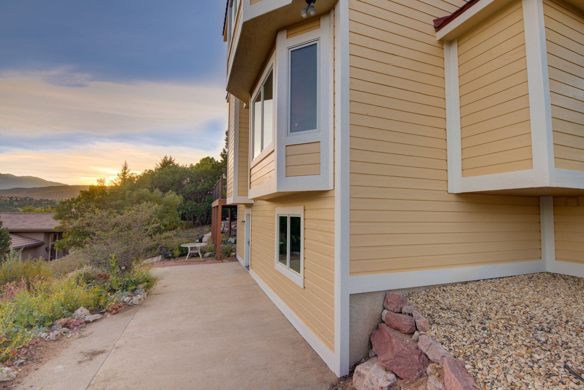 a yellow house with a driveway leading to it