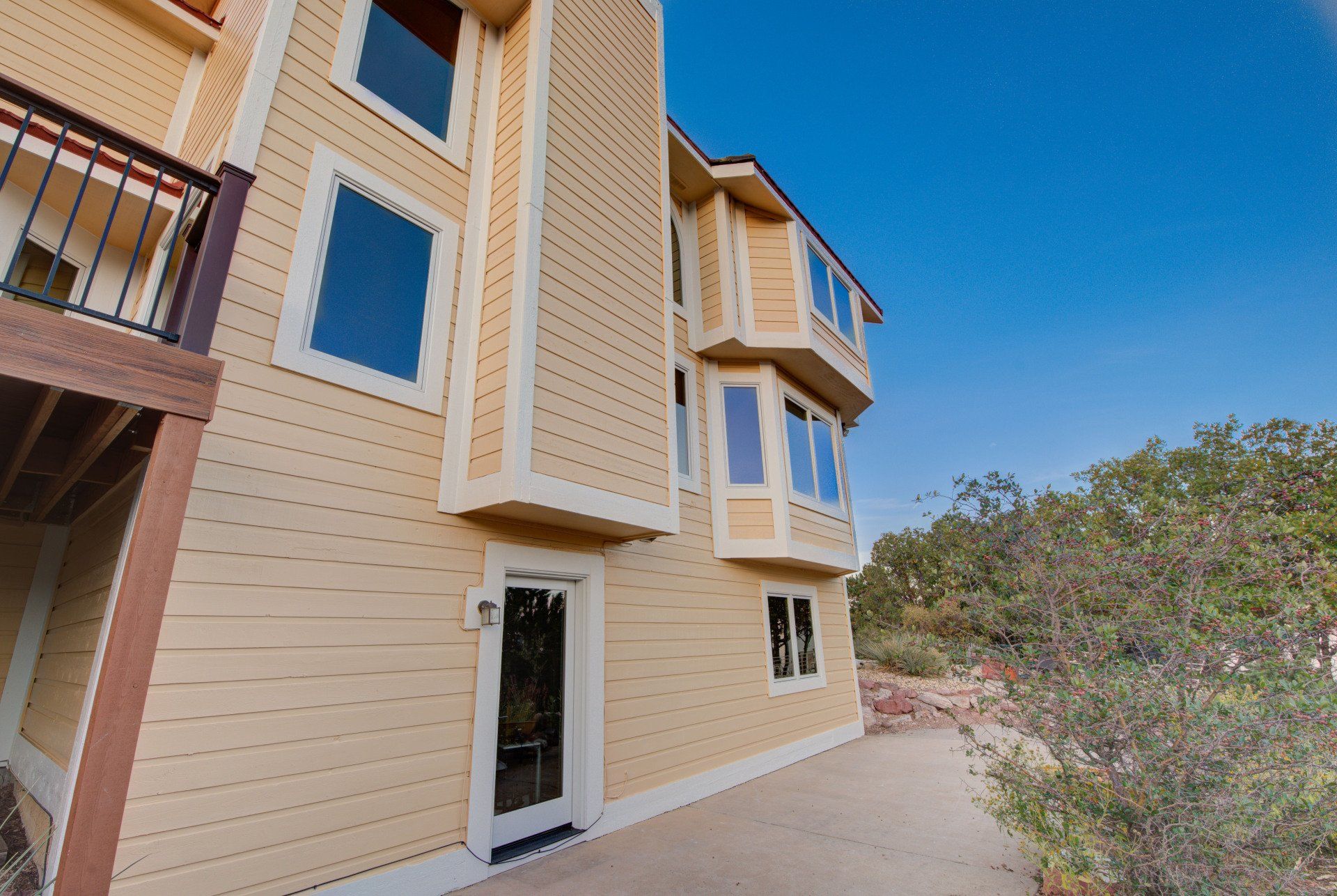 a large yellow house with a balcony and lots of windows