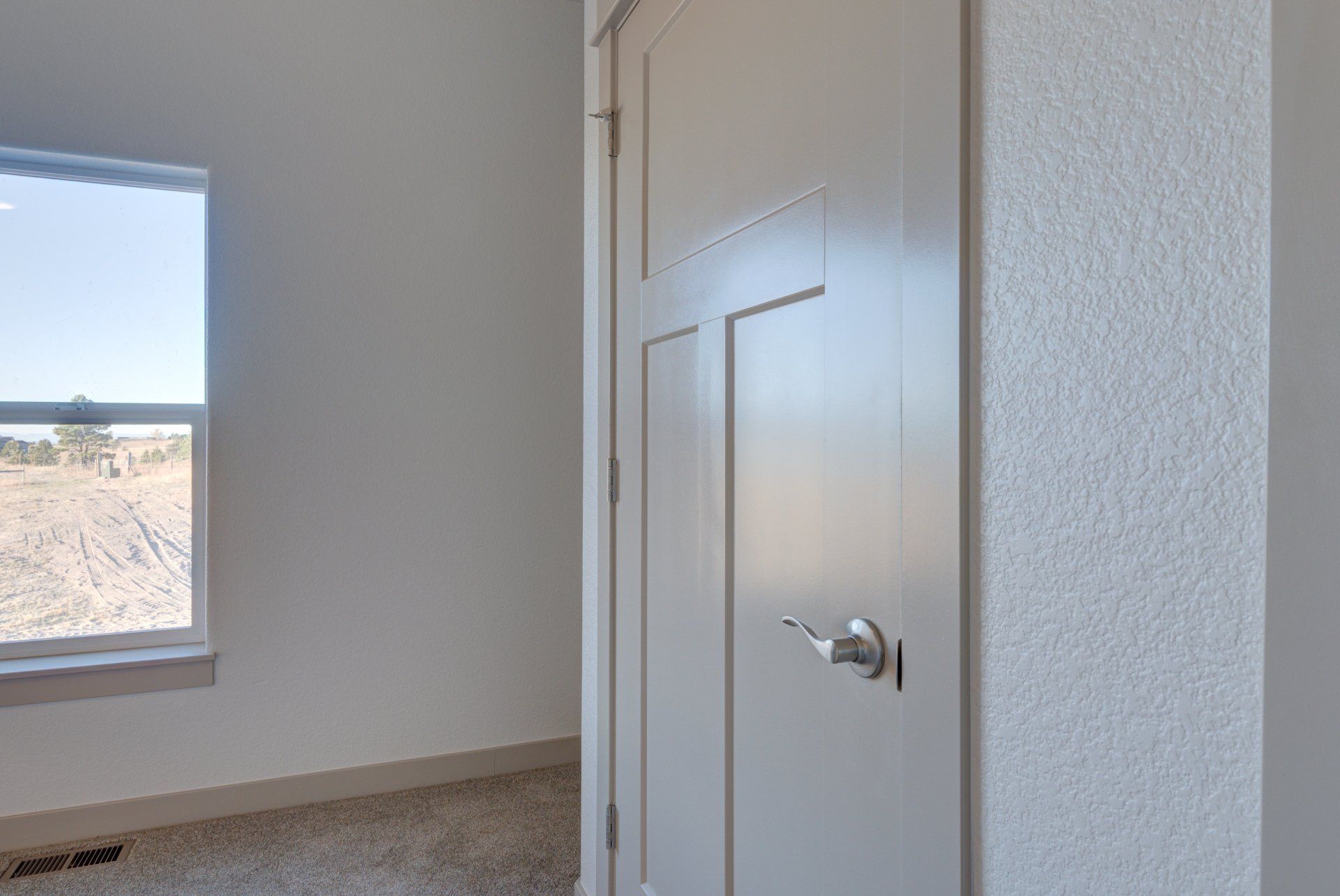 There is a door in the middle of a room with a window.