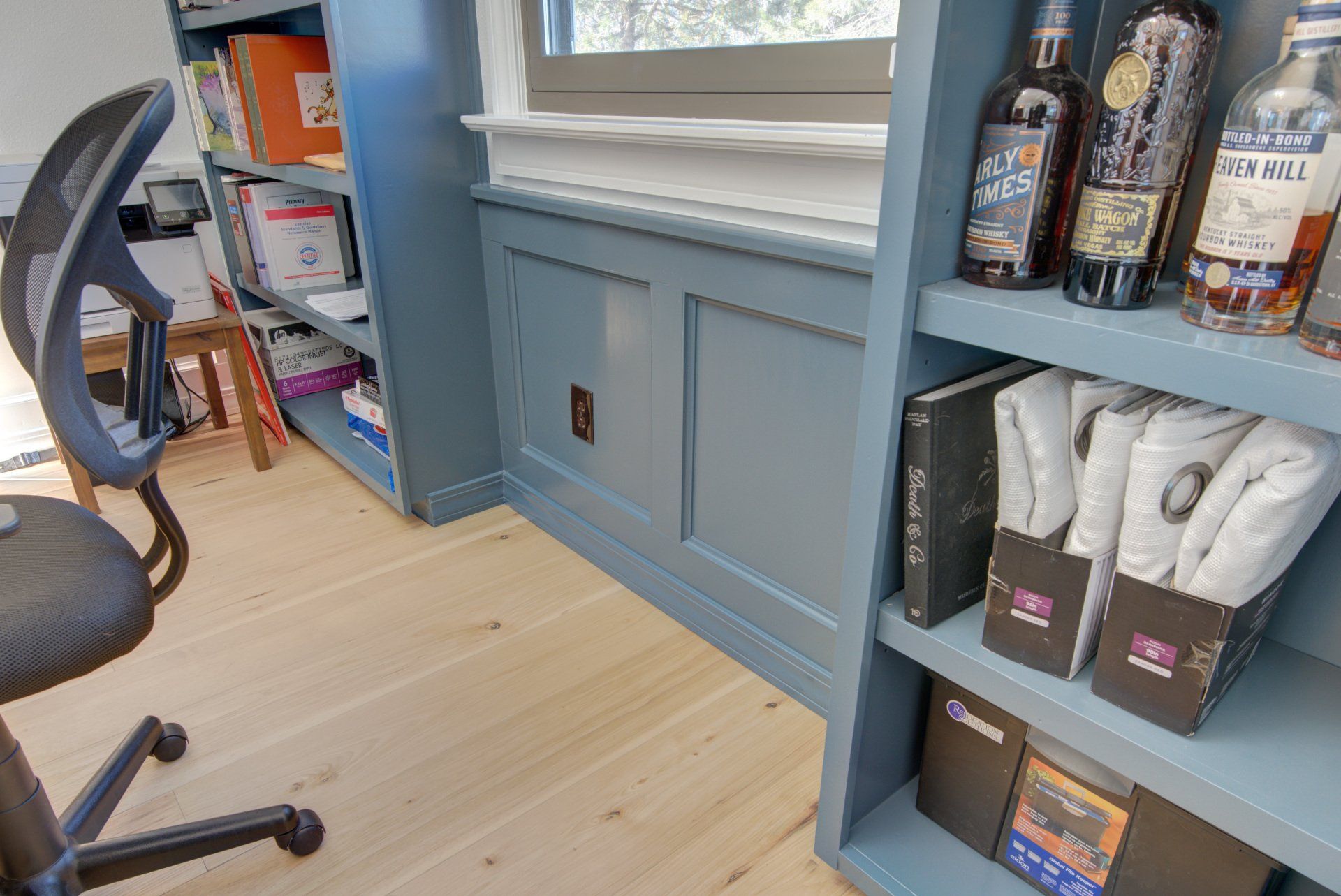 There are many bottles of alcohol on the shelves in this room.