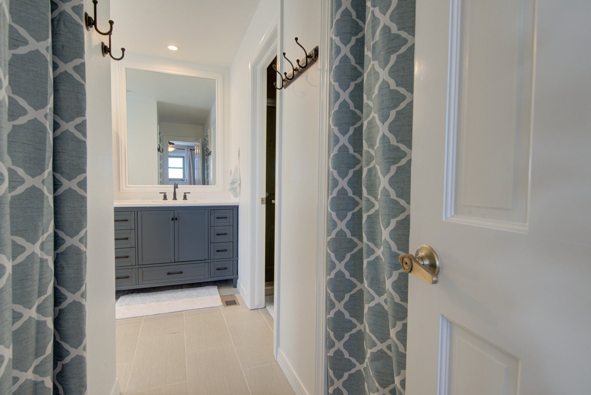A bathroom with a sink , mirror and shower curtain.