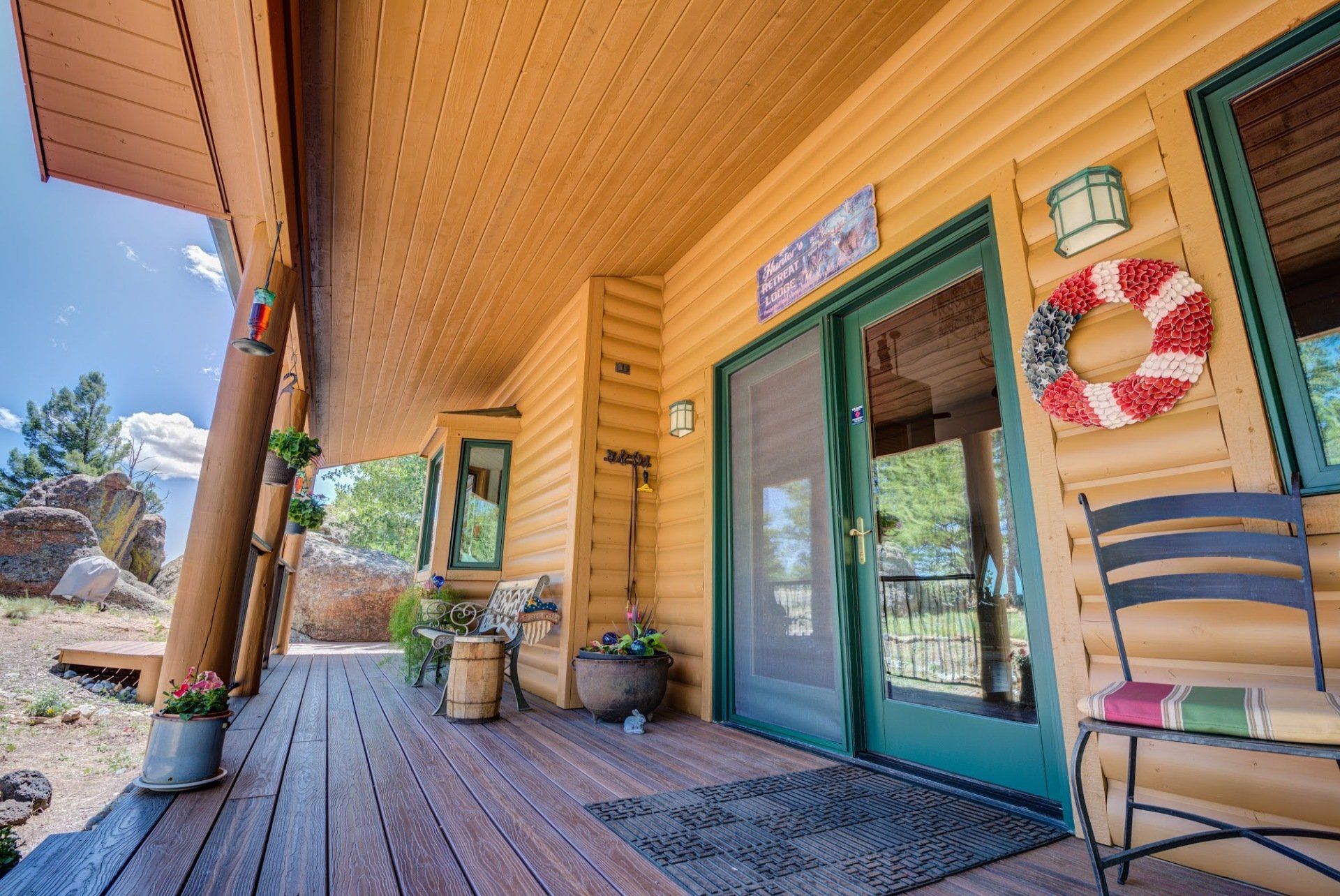 A log cabin with a porch and sliding glass doors.
