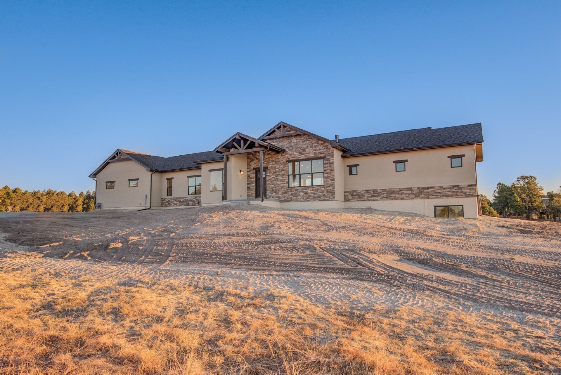 A large house is sitting on top of a dirt hill.