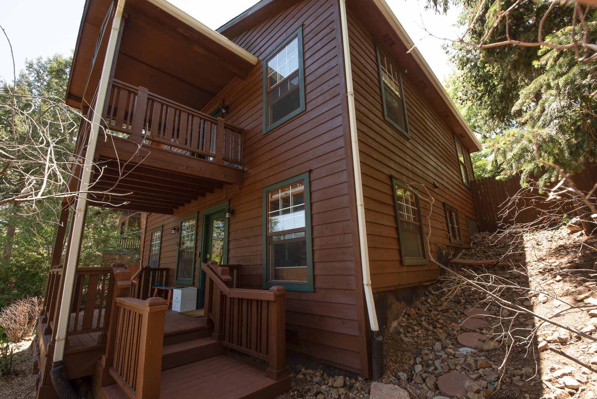 A brown house with a balcony and stairs
