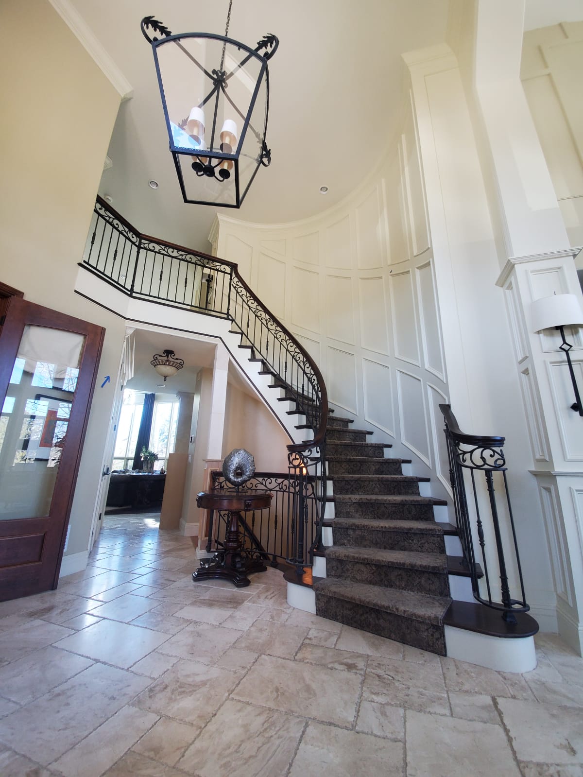A large staircase in a house with a chandelier hanging from the ceiling