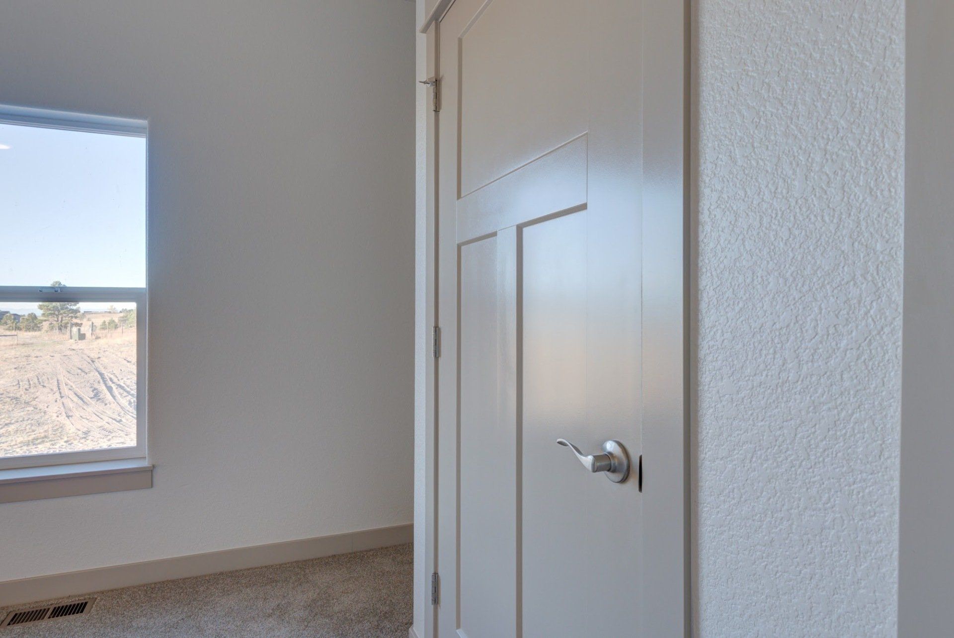 There is a door in the middle of a room with a window.