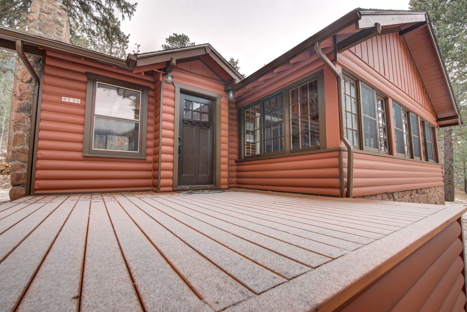 A log cabin with a large deck in front of it