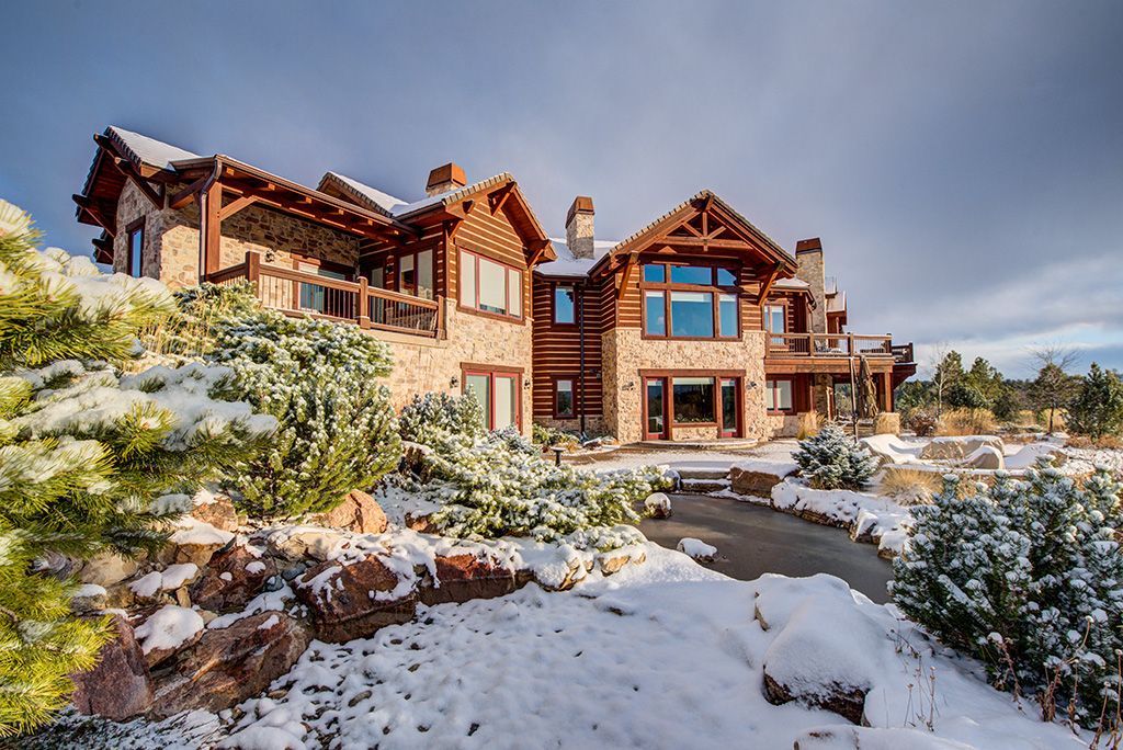 Exterior painting in fall - a large house sitting on top of a snow covered hill.