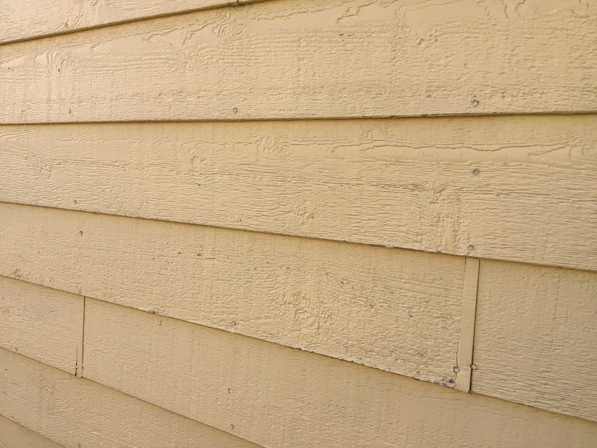 A close up of a beige siding on a house.