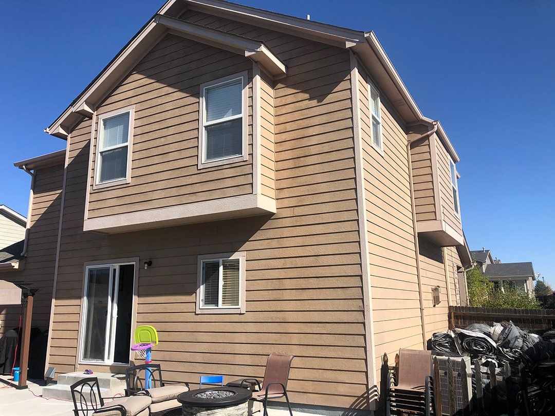 A house with a lot of windows and a blue sky in the background