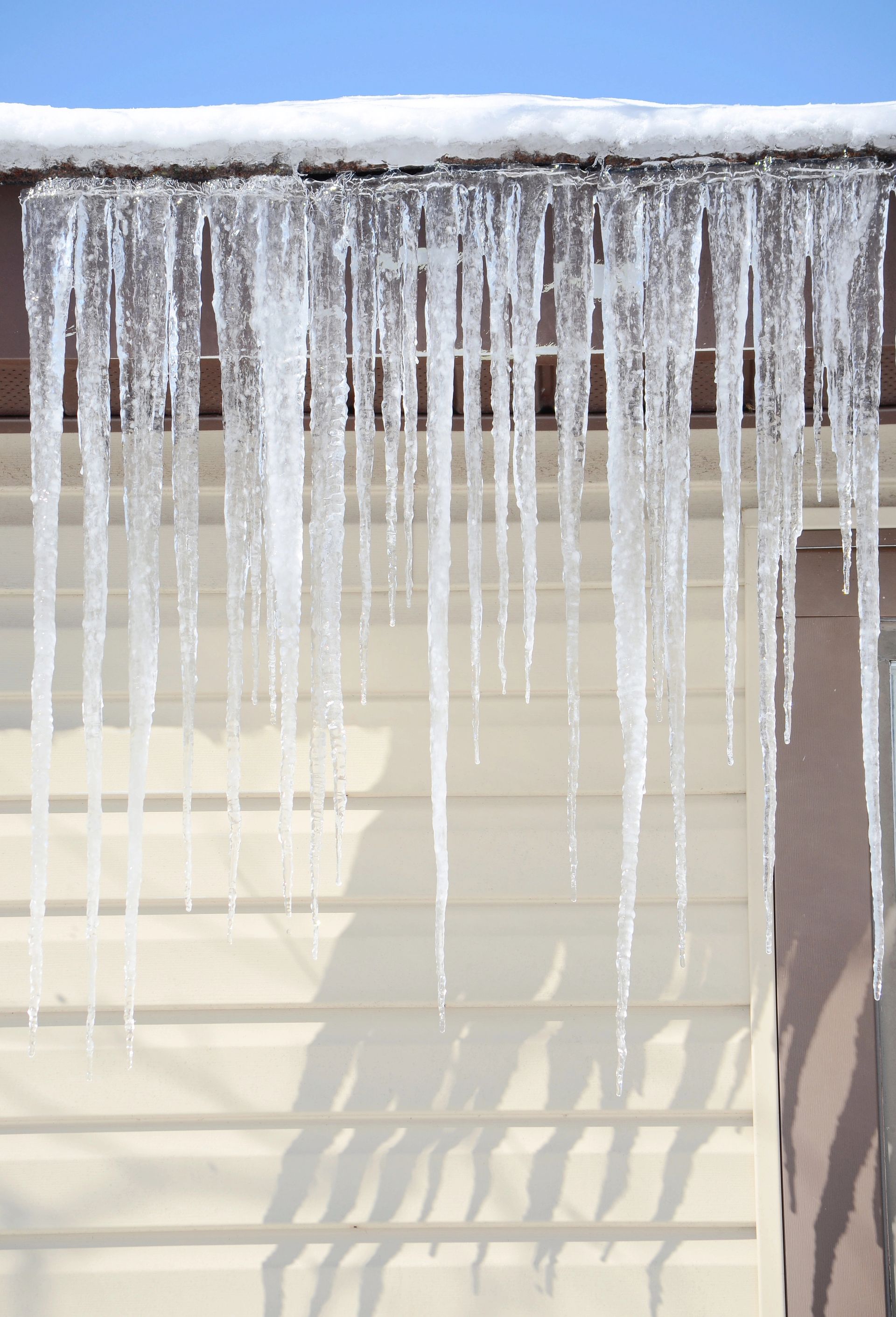 Icicles are hanging from the roof of a house