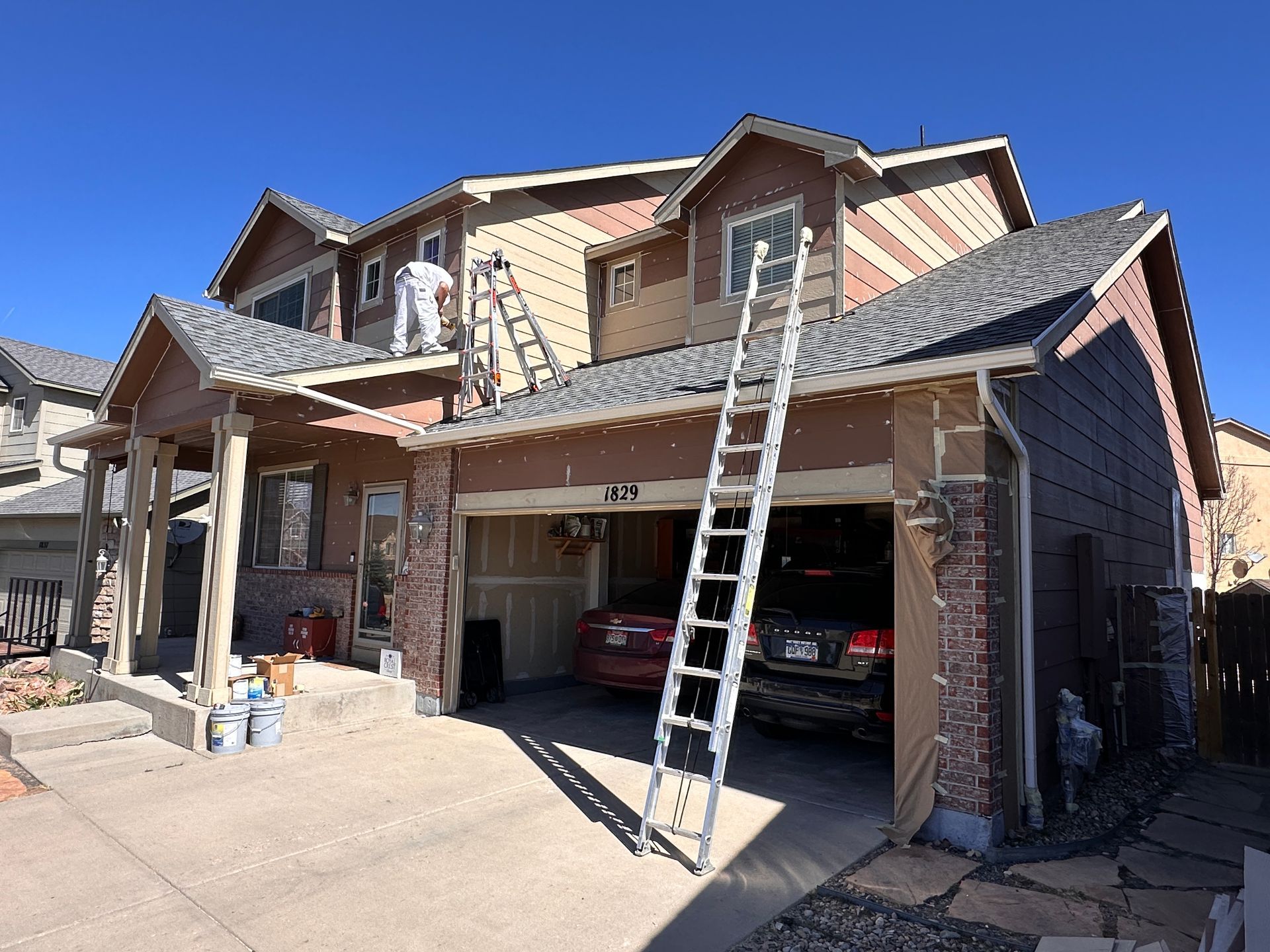 A large house with a lot of windows and trees in front of it. Front Range Painters Crew at work in Colorado Springs.