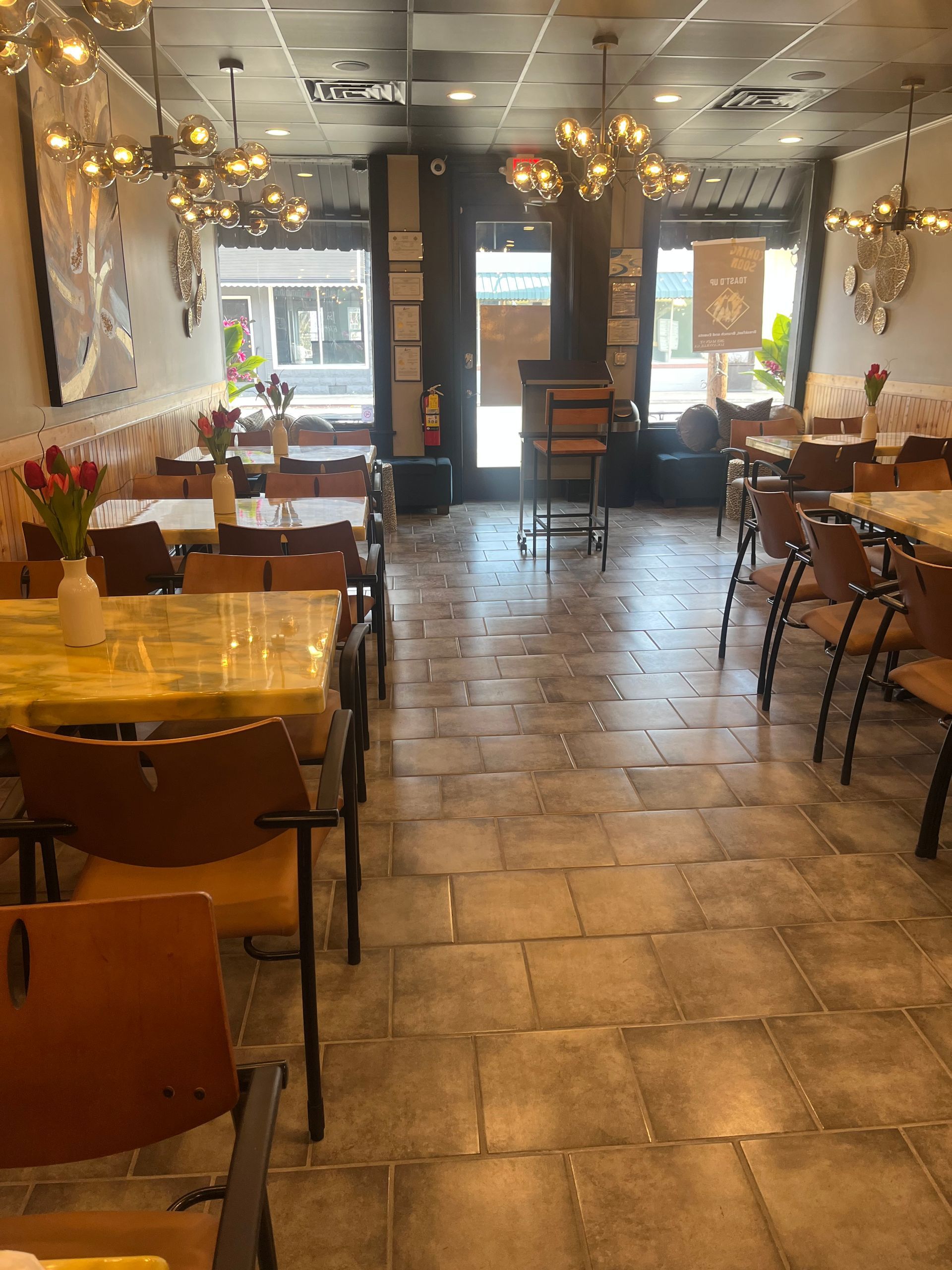 A restaurant with tables and chairs and a tiled floor.