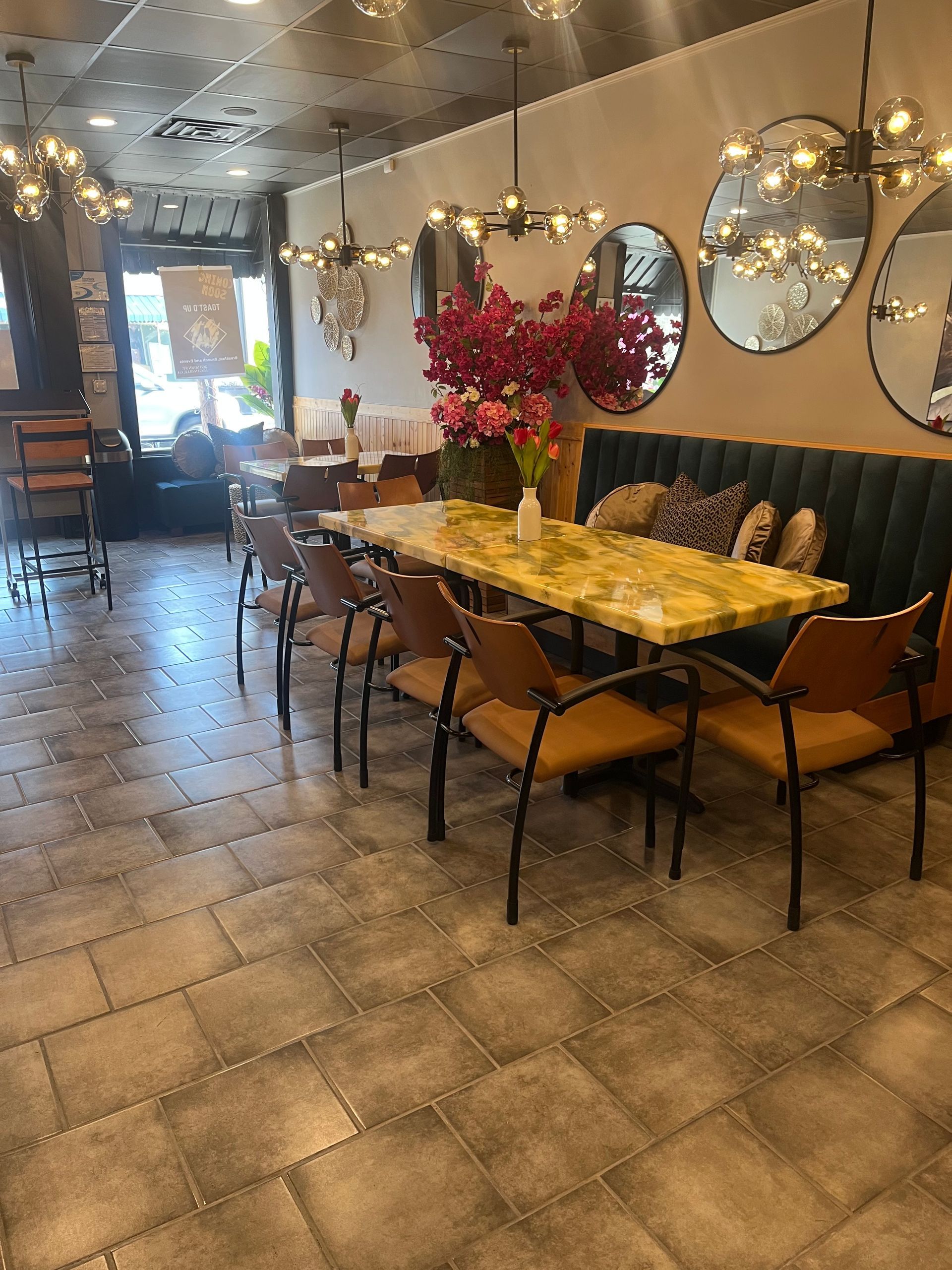 A restaurant with tables and chairs and mirrors on the wall