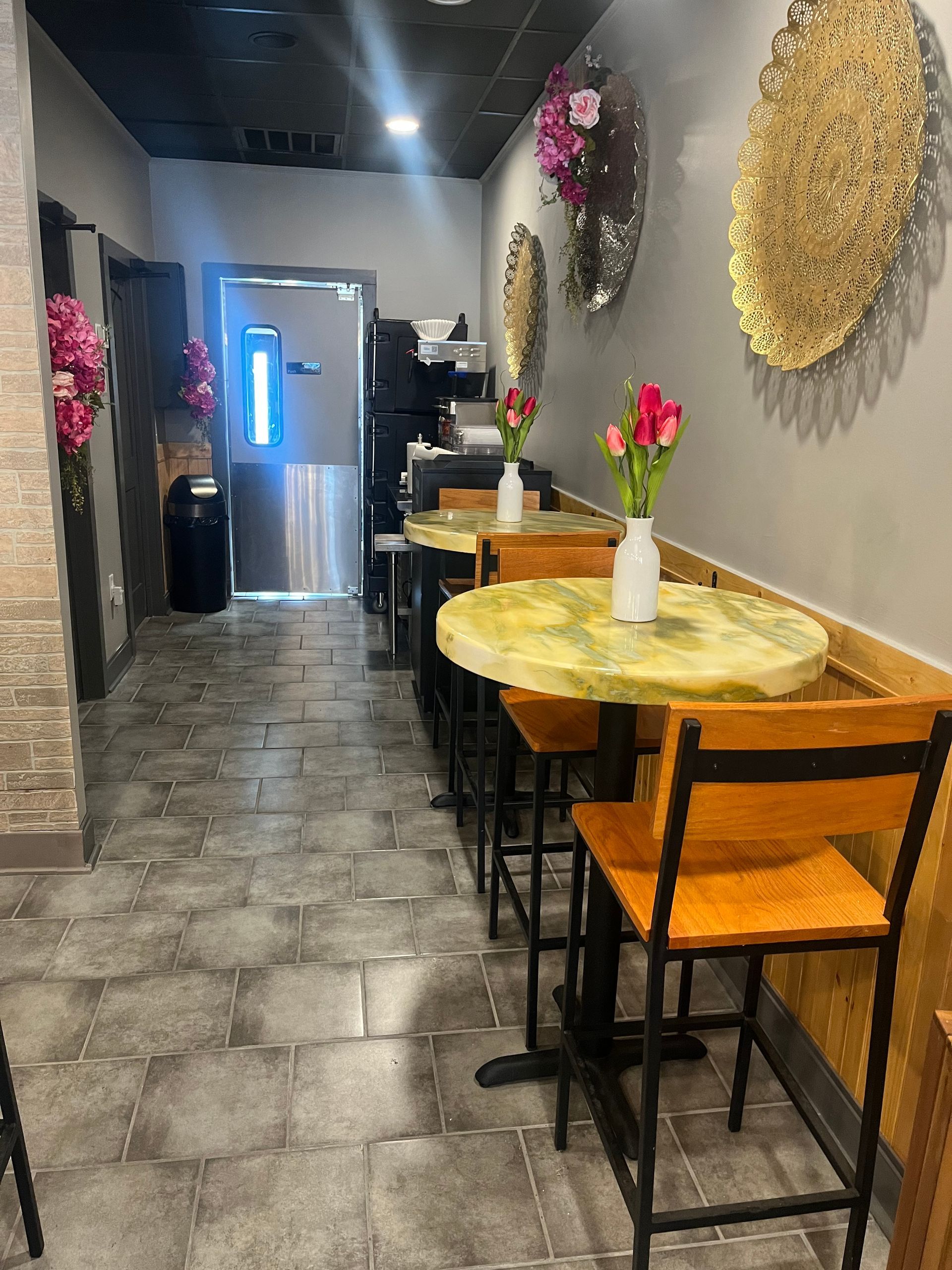 A long hallway with tables and chairs in a restaurant