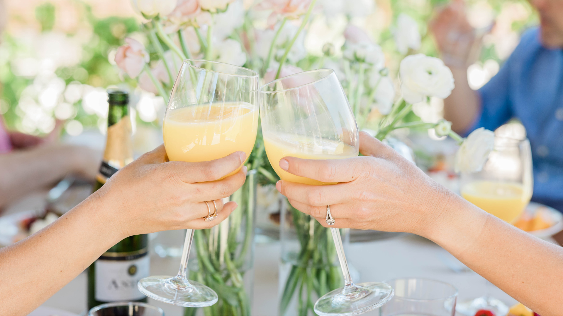 two people are toasting with champagne glasses at a table .