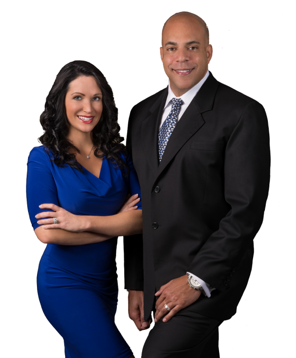 Woman in blue dress and man in suit, smiling, standing close together.