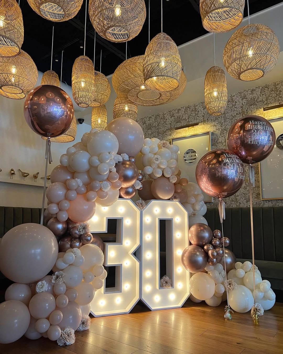 A room decorated with balloons and lights for a 30th birthday.